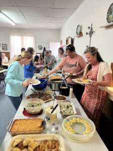 Congregation members in a potluck buffet line at Hays Chapel