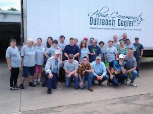 Members of Newberry Chapel gathered under a sign reading, "Alma Community Outreach Center
