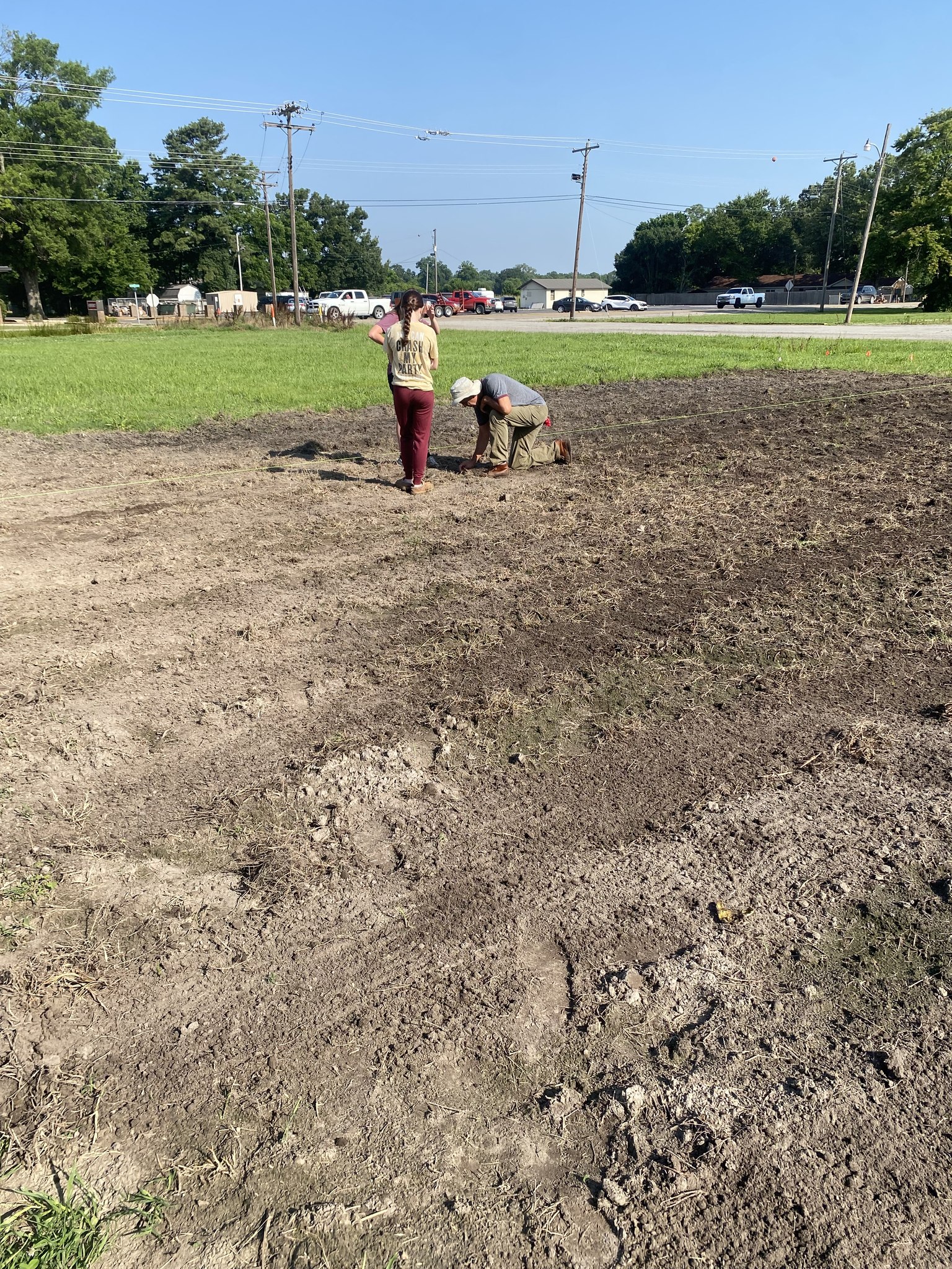 Checking seed depth and seeing the results of the planter Dr. Gill Giese works with the Newport High School students